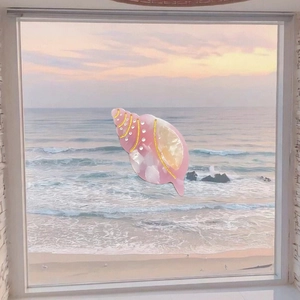 Detailed pink and white conch hair clip with gold dots over a sunset beach backdrop