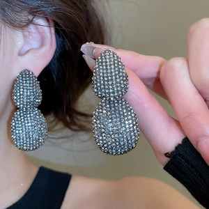 Detailed macro view of large oval vintage stud earrings with sparkling grey rhinestones