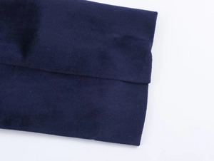 Close-up of deep blue velvet fabric showing fine texture and double-stitched seams
