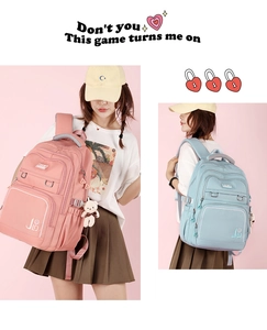 Detail of pink and blue school backpacks with multiple pockets and cute bear charm