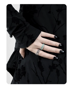 Close-up of S925 silver hollow mesh ring and green gemstone ring on a hand
