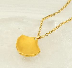 Detailed view of 18K gold plated stainless steel ginkgo leaf pendant on a fine chain