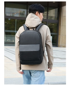 Outdoor view of professional black leather backpack on back showing fit and scale