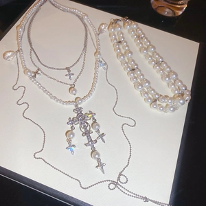 Detail of multi-layer pearl necklace and bracelet set with rhinestone cross pendant