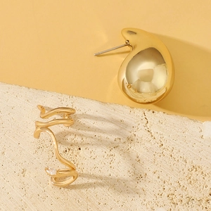 Detail of elegant gold-toned ear cuff with cubic zirconia on a minimalist stone base