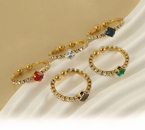 Detailed close-up of five 18k gold plated stainless steel rings with colorful square stones