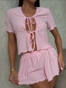 Detail of pink knitted loungewear set with lace texture and ribbon tie-up design