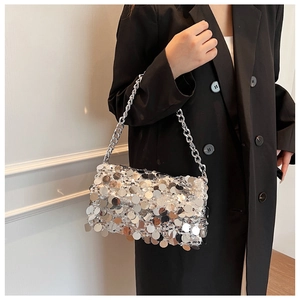 Close-up of silver sequin handbag with large round discs and chunky metal chain strap