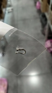 Detailed view of silver U-shaped nose clip with sparkling crystal stone in packaging