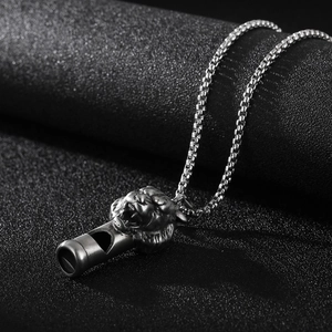 Detailed close-up of retro lion head whistle pendant in antique finish on box chain necklace