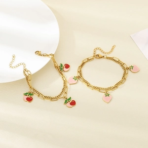 Detail of 18K gold-plated double-layer anklets with red and pink enamel cherry charms