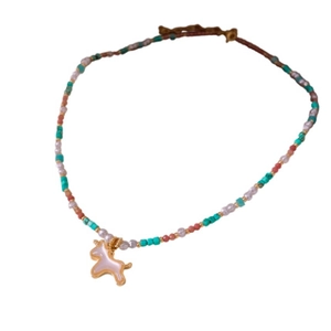 Vintage style beaded necklace with colorful stones and a gold unicorn pendant on white