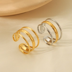 Detail of three-layered open rings in gold and silver finish with textured hammering