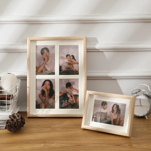 Set di cornici in legno naturale con passepartout bianco su una scrivania in legno