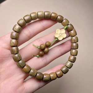 Armband aus grünem Sandelholz mit tonnenförmigen Perlen und gelbem Blumenanhänger