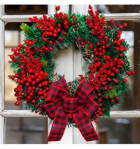 Close-up of Christmas wreath with red berries, pine needles and buffalo plaid bow decoration