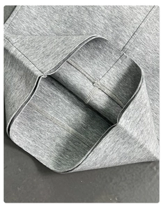 Macro shot of grey cotton fabric showing reinforced stitching and high-quality hem detail