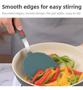 Deep green silicone spatula with stainless steel handle frying colorful bell peppers