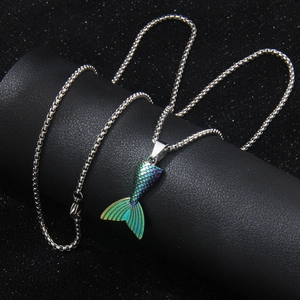 Rainbow stainless steel mermaid tail necklace with iridescent scales on black background