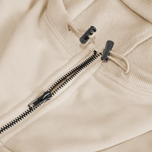 Close-up of a premium metal zipper and drawstring on a beige hooded sweatshirt