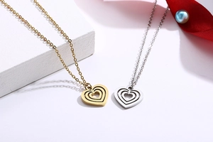 Detail view of heart-shaped multi-layered necklaces in gold and silver steel finish