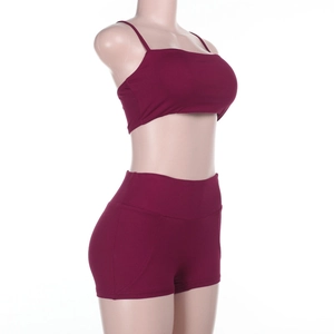 Vista laterale del set sportivo bordeaux con crop top e pantaloncini a vita alta