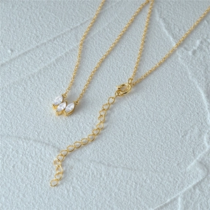 Detail of gold necklace lobster clasp and adjustable tail chain with marquise stones