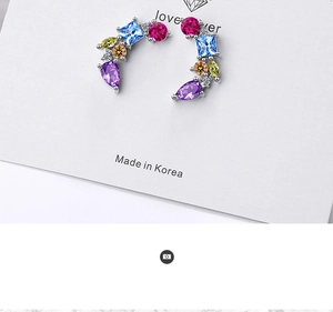 Detail shot of colorful zircon stud earrings featuring multi-color faceted gemstones
