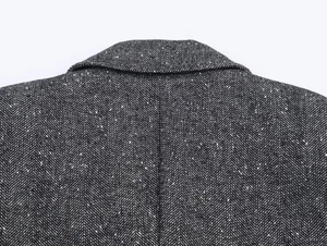 Detail shot of black and grey herringbone wool blazer fabric with refined fiber texture