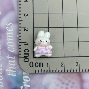Macro detail of mini resin rabbit charm with pink polka dots and 2cm scale reference