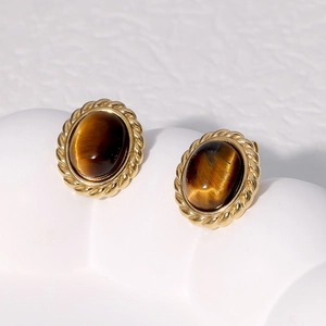 Macro detail of vintage gold-plated stainless steel studs set with tiger eye stones