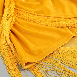 Détail macro du tissu en velours doré avec de longues franges soyeuses et fluides
