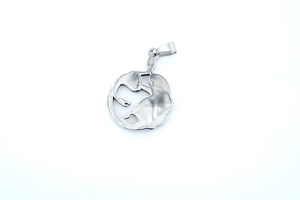 Macro shot of silver Medusa head pendant showing detailed vintage metal texture on white background