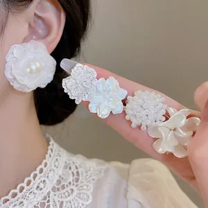 Set of ten sweet flower stud earrings featuring pearls and white resin floral designs