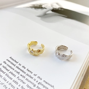 Macro detail of irregular hammered texture rings with zircon on a vintage book