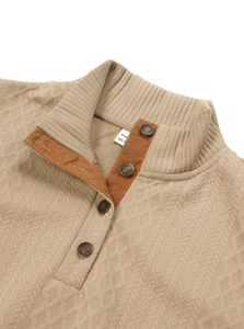 Dettaglio del maglione kaki con bottoni in metallo e motivo a maglia a rombi