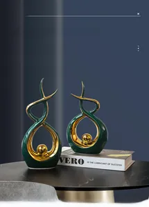 Detail of modern green ceramic abstract sculpture with gold electroplated sphere on marble