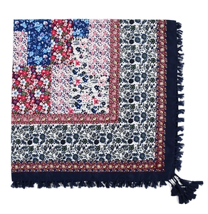 Detail shot of bohemian floral square scarf featuring intricate blue and red jacquard tassels
