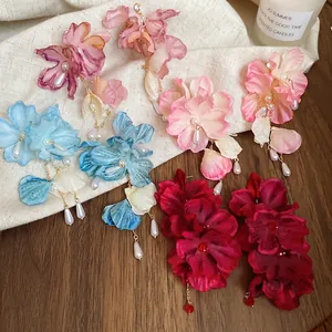 Floral fabric petal earrings with pearls in five colors on a rustic linen background