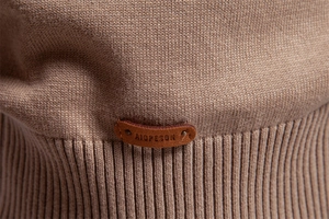 Macro shot of brown knit fabric texture and leather logo patch on men's sweater