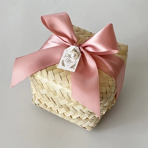 Detail of handmade woven bamboo gift box with pink satin ribbon and pearl thank you card