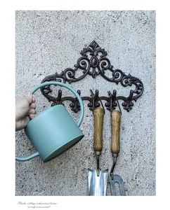 Detail of vintage cast iron wall rack with five hooks and decorative scroll patterns