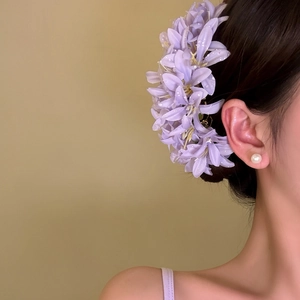 Elegant purple fabric flower hair pin accessory for women shown in a detailed close-up view