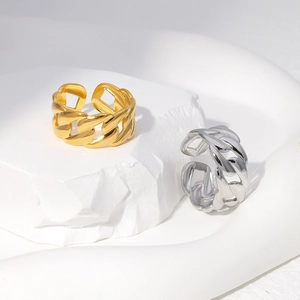 Detail of gold and silver stainless steel chain rings on white textured stone