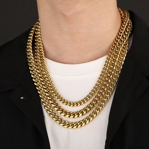 Gold multi-layer stainless steel Cuban link necklaces worn on a model over a white T-shirt