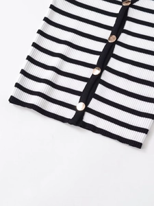 Close-up of black and white striped knit fabric with elegant gold metal buttons