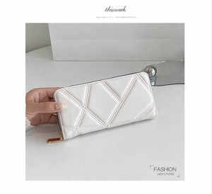 Detailed view of a white quilted long wallet for women with golden zipper and PU leather texture