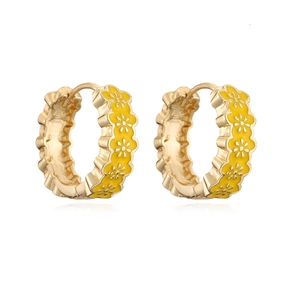 Macro shot of gold hoop earrings with vibrant yellow enamel flower patterns on white base