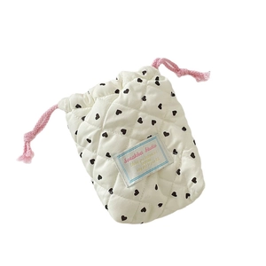 Quilted heart pattern camera storage bag with pink drawstring in creamy white