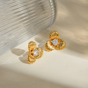 Macro shot of 18k gold stainless steel petal earrings with sparkling center zircon